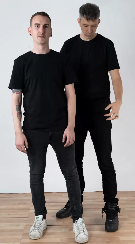 Portraitfoto von David und Sven, Gründer von kombinat79. beide tragen schwarz. Sie scheinen abgelenkt zu sein und scherzen.